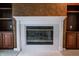 White fireplace featuring glass doors and white tile, with built in wood cabinets on both sides at 4232 Bunting Ln, Columbus, IN 47203