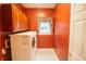 Well-equipped laundry room with wooden cabinets, modern machines, and a window for natural light at 4232 Bunting Ln, Columbus, IN 47203