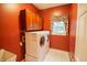 Laundry room featuring modern washer and dryer, wooden cabinets, and a bright window at 4232 Bunting Ln, Columbus, IN 47203