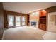 Sunlit living room featuring a fireplace, built-in shelving, and access to the backyard at 4232 Bunting Ln, Columbus, IN 47203