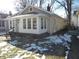 Tan house with white sunroom and snowy yard at 4712 Caroline Ave, Indianapolis, IN 46205