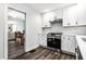 Modern kitchen with stainless steel oven, white cabinets, and view of dining area at 4926 Crittenden Ave, Indianapolis, IN 46205