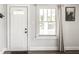 Well-lit living room featuring a white door and a large window at 4926 Crittenden Ave, Indianapolis, IN 46205