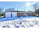 Brick house with attached two-car garage and snow covered yard at 6240 W Mills Rd, Indianapolis, IN 46221