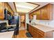 Kitchen with wood cabinets, black appliances, and a view of the bathroom at 710 Eagle Pkwy # 15, Brownsburg, IN 46112