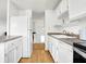 White kitchen cabinets, hardwood floors, and a view to the dining area at 7803 Opelika Ct, Indianapolis, IN 46217