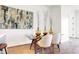 Modern dining area with glass table, beige chairs, and abstract wall art at 855 N East St # 302, Indianapolis, IN 46202