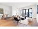 Bright and airy living room with hardwood floors, modern furniture, and access to balcony at 855 N East St # 302, Indianapolis, IN 46202