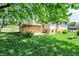 Backyard featuring a brick exterior, a small patio, and a lawn with a tree offering shade at 9157 Neptune Dr, Indianapolis, IN 46229