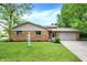 Charming brick home featuring a well-maintained lawn and attached two-car garage at 9157 Neptune Dr, Indianapolis, IN 46229