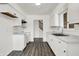 Bright kitchen featuring white cabinets, stairs, and modern countertops, and wood-look flooring at 9157 Neptune Dr, Indianapolis, IN 46229