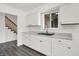 Updated kitchen with white cabinets, modern countertops, stainless steel sink, stairs, and wood-look flooring at 9157 Neptune Dr, Indianapolis, IN 46229