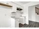 Modern kitchen with white cabinets and gray countertops, complemented by wood-look floors and stainless hood at 9157 Neptune Dr, Indianapolis, IN 46229