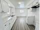 Long kitchen with white cabinets and grey wood-look floors at 9157 Neptune Dr, Indianapolis, IN 46229