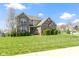 Beautiful two-story home featuring a well-manicured lawn, green shrubs, and blossoming trees on a sunny day at 11383 Sea Side Ct, Fishers, IN 46040