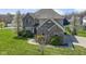 Attractive two-story brick home with manicured lawn, shrubs, and sidewalks, framed by blossoming trees at 11383 Sea Side Ct, Fishers, IN 46040