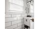 Bright bathroom featuring a white vanity, black hardware, subway tile, and a window with natural light at 1319 N New Jersey St, Indianapolis, IN 46202