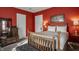 Bright red bedroom featuring a wood-framed bed, classic dressers, and soft carpet for a cozy feel at 1319 N New Jersey St, Indianapolis, IN 46202