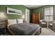 Green bedroom featuring a full bed, hardwood dresser, and window for a serene and comfortable space at 1319 N New Jersey St, Indianapolis, IN 46202