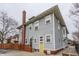 Charming grey home featuring a bright yellow door, brick chimney, and well-maintained siding at 1319 N New Jersey St, Indianapolis, IN 46202