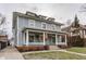 Elegant grey house with a wide front porch, white columns, and lush greenery, enhancing its curb appeal at 1319 N New Jersey St, Indianapolis, IN 46202