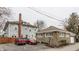 Exterior shot of a grey home with a brick chimney, featuring a driveway and parking area at 1319 N New Jersey St, Indianapolis, IN 46202