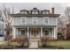 Inviting grey home with a front porch, classic columns, and well-kept landscaping, creating a welcoming entrance at 1319 N New Jersey St, Indianapolis, IN 46202