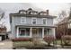 Beautiful grey house with a charming front porch, white columns, and well-manicured yard at 1319 N New Jersey St, Indianapolis, IN 46202