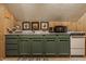 Kitchen area with green cabinets, wood-paneled walls, and appliances providing a functional and stylish cooking space at 1319 N New Jersey St, Indianapolis, IN 46202