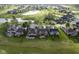 Aerial view of the golf course community with a pond, mature trees, and landscaping at 16395 La Paloma Ct, Noblesville, IN 46060