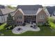 Aerial view of the home with a large backyard featuring a custom patio, landscaping, and fire pit at 16395 La Paloma Ct, Noblesville, IN 46060