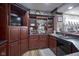 Basement bar with dark wood cabinets and a brick front at 16395 La Paloma Ct, Noblesville, IN 46060