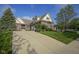 Well-maintained brick home showcasing a spacious driveway, lush lawn, and mature landscaping at 16395 La Paloma Ct, Noblesville, IN 46060