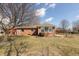 Backyard view featuring a well kept yard, a tidy garden area and an attractive brick house with bright windows at 306 Vinewood N Dr, Brownsburg, IN 46112