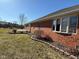 Exterior view of brick house with well-kept lawn and tidy garden areas on a bright and sunny day at 306 Vinewood N Dr, Brownsburg, IN 46112