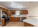 Functional kitchen boasts warm wood cabinetry, white countertops, and modern stainless steel appliances at 306 Vinewood N Dr, Brownsburg, IN 46112