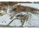 Aerial view of a house and detached garage on a snowy lot near a road at 4305 Five Points Rd, Indianapolis, IN 46239