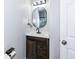 Updated bathroom with an oval mirror and dark vanity at 4305 Five Points Rd, Indianapolis, IN 46239