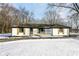 Front view of a charming white brick ranch house with black accents and a porch at 4305 Five Points Rd, Indianapolis, IN 46239