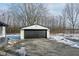 White garage with a black door in a snowy landscape at 4305 Five Points Rd, Indianapolis, IN 46239