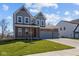 Attractive home with a brick and gray facade, complemented by a lush green lawn and a convenient three-car garage at 5511 Sienna Ct, Brownsburg, IN 46112