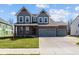 Charming two-story home featuring a brick and gray exterior with a well-manicured lawn and a spacious three-car garage at 5511 Sienna Ct, Brownsburg, IN 46112