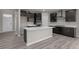 Modern kitchen showcasing an island, black cabinets, and stainless steel appliances, adjacent to the welcoming living area at 5511 Sienna Ct, Brownsburg, IN 46112