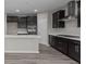 Contemporary kitchen with a center island, black cabinets, and stainless steel appliances, complete with sleek hardwood floors at 5511 Sienna Ct, Brownsburg, IN 46112