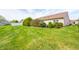 Large grass backyard features mature manicured landscaping with a white fence in the background at 7259 Registry Dr, Indianapolis, IN 46217