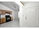 Galley kitchen with oak cabinets, black appliances, and tile floor at 7259 Registry Dr, Indianapolis, IN 46217
