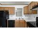 L-shaped kitchen with oak cabinets and black appliances at 7259 Registry Dr, Indianapolis, IN 46217