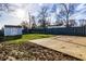 Partially fenced backyard featuring a storage shed, grassy area, and a paved section, perfect for outdoor activities at 8415 E 10Th St, Indianapolis, IN 46219