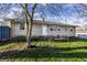 Inviting single-story home boasts a stone exterior, well-manicured lawn, and a welcoming front entrance at 8415 E 10Th St, Indianapolis, IN 46219