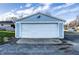 Detached two-car garage with a large white door and light blue siding, providing ample parking and storage at 8415 E 10Th St, Indianapolis, IN 46219